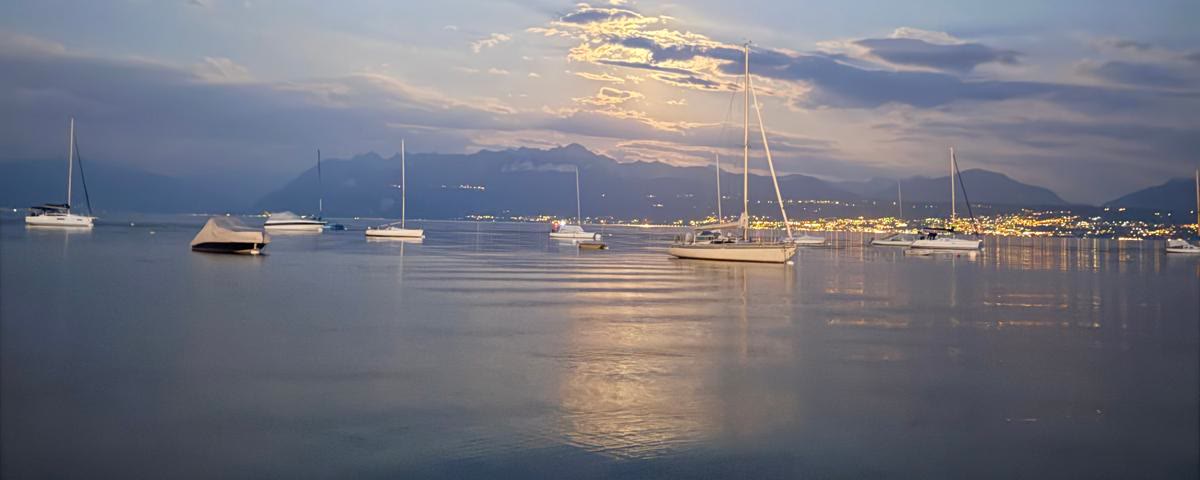 Voiliers au crépuscule sur le Léman, lumières de la rive